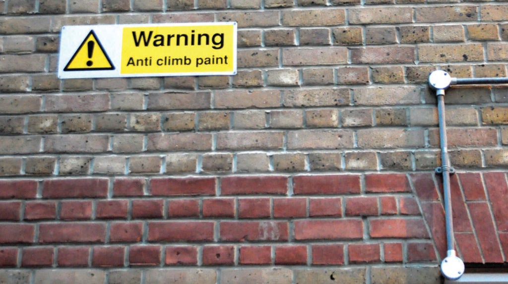 A brick wall covered in anti-climb paint.