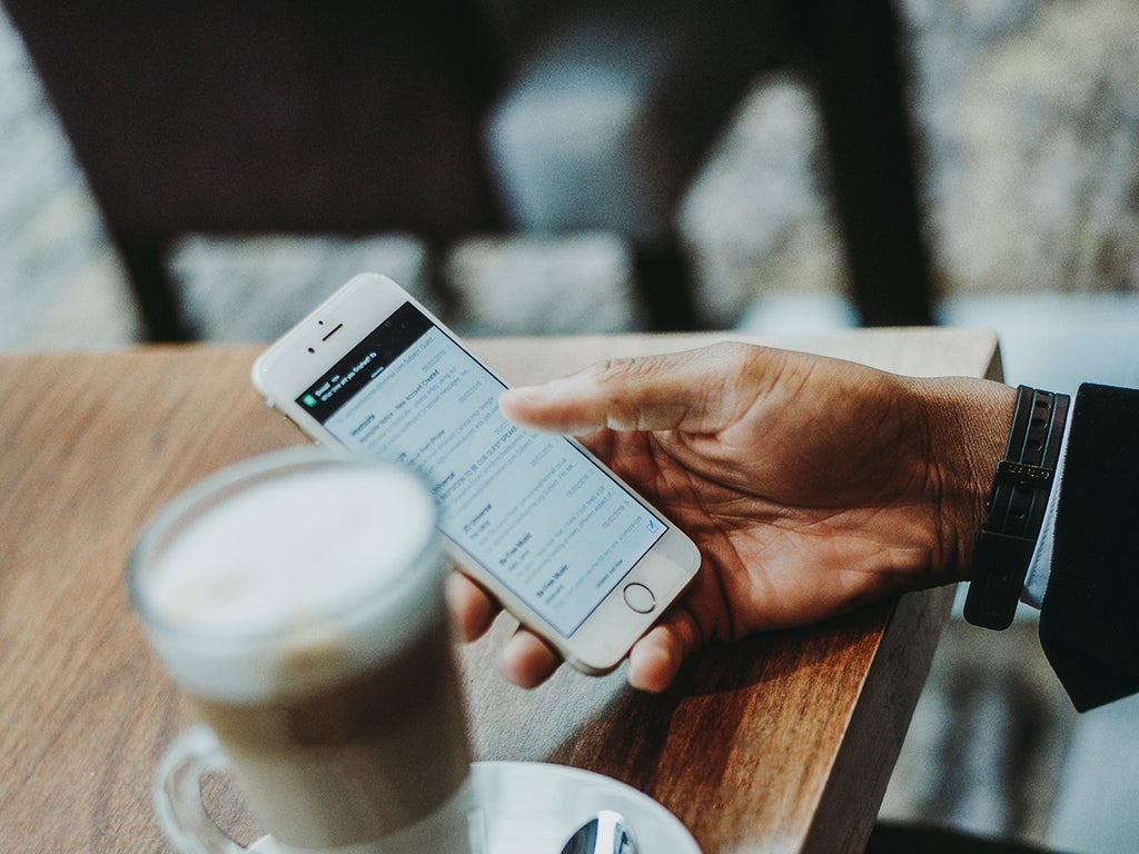 Une personne utilisant un téléphone et une connexion Wi-Fi dans un café.