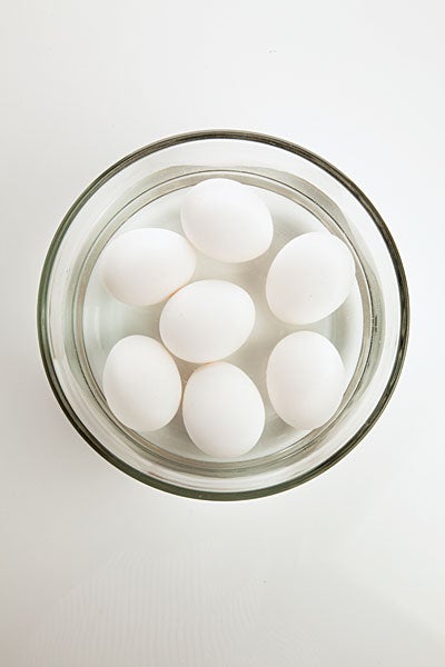 Seven eggs in a glass bowl of water.