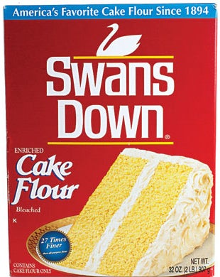 A photo of a box of cake flour with a yellow cake with vanilla frosting on the front.