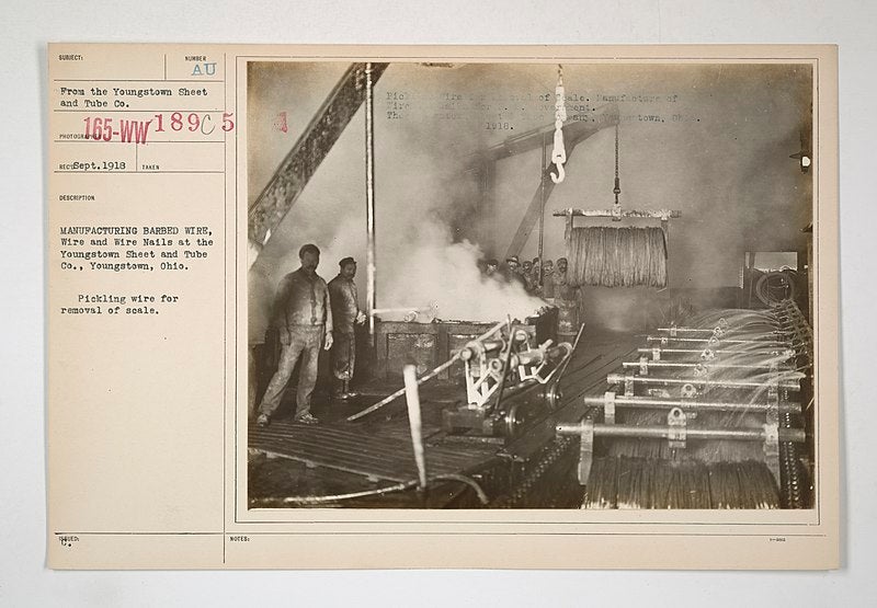 Military galvanized barb wire production in a black and white factory photo