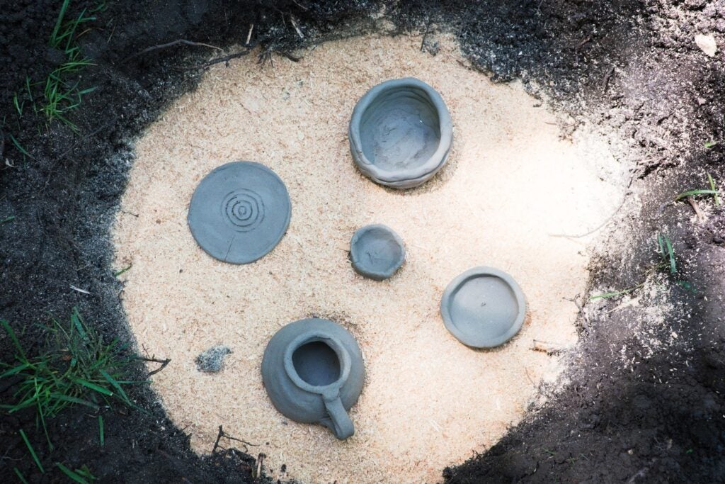 pottery in a hole full of sawdust