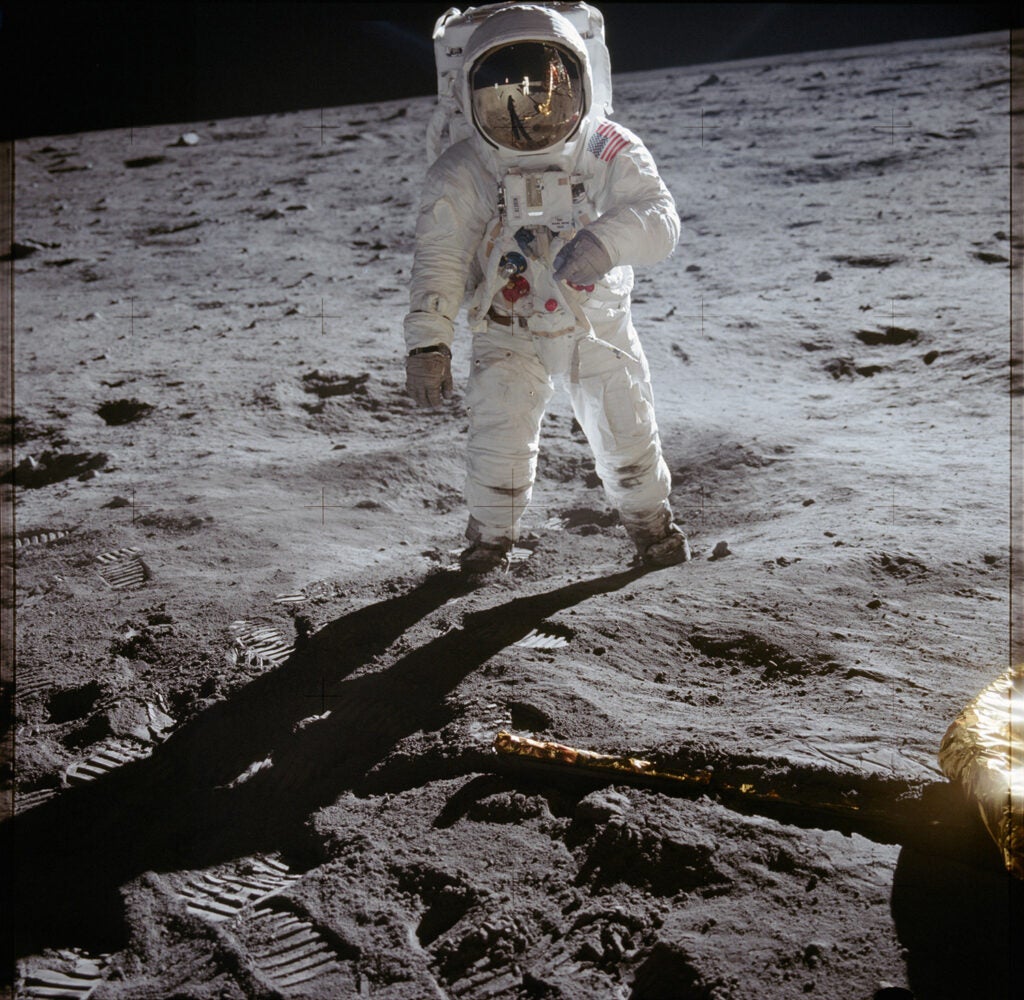 Astronaut Buzz Aldrin walks on lunar surface near leg of Lunar Module