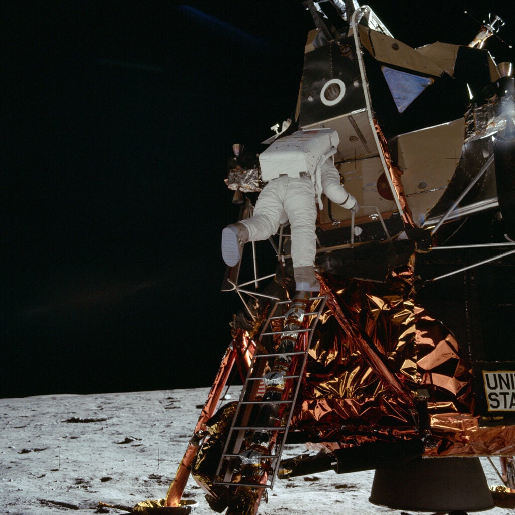 Astronaut Buzz Aldrin descends steps of Lunar Module ladder to walk on moon