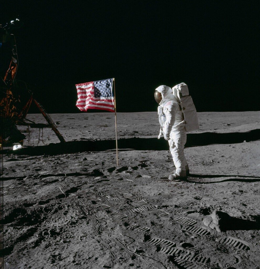 Astronaut Buzz Aldrin poses for photograph beside deployed U.S. flag