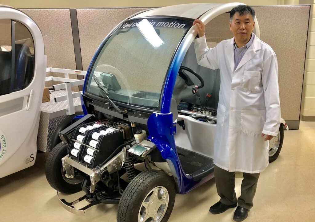 Professor Xianguo Li with his fuel cell test vehicle in his lab