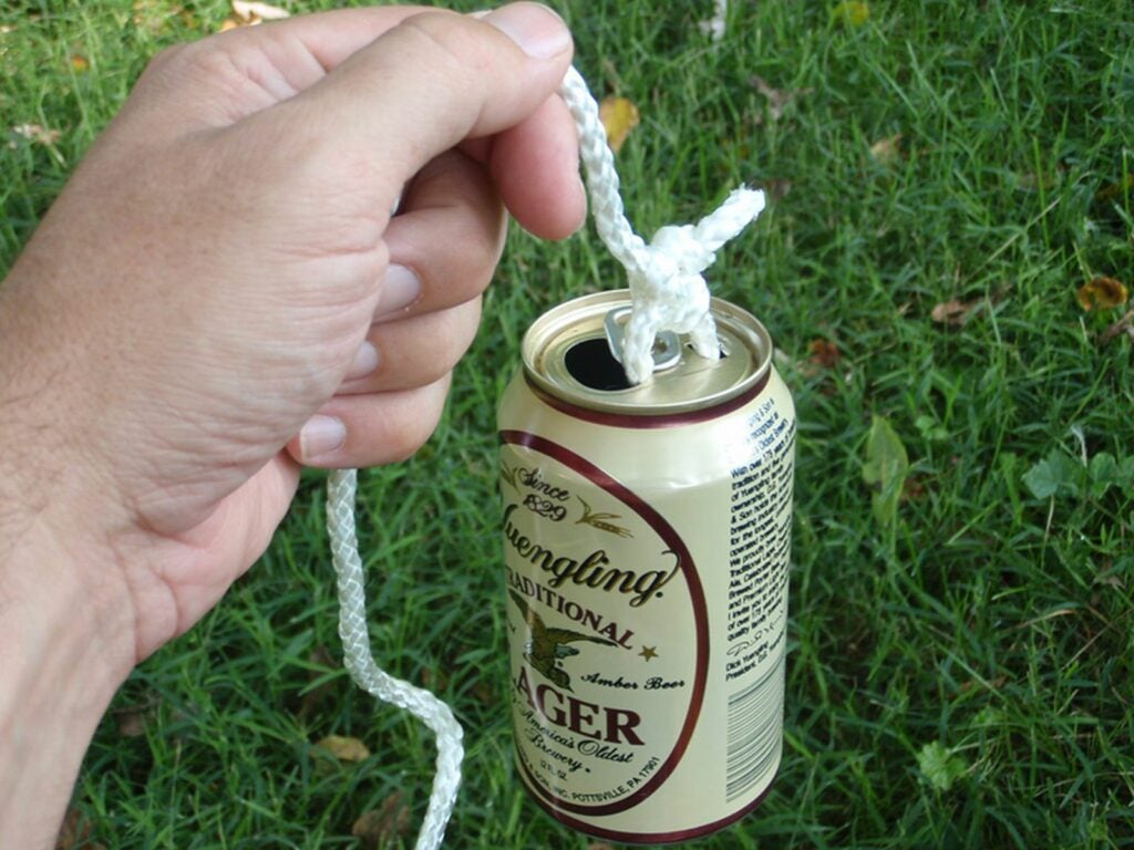 An empty beer can tied to a string acts as a fishing float.