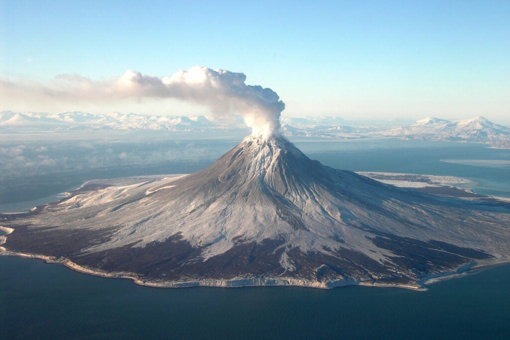 volcanic mountain with smoke coming out the top