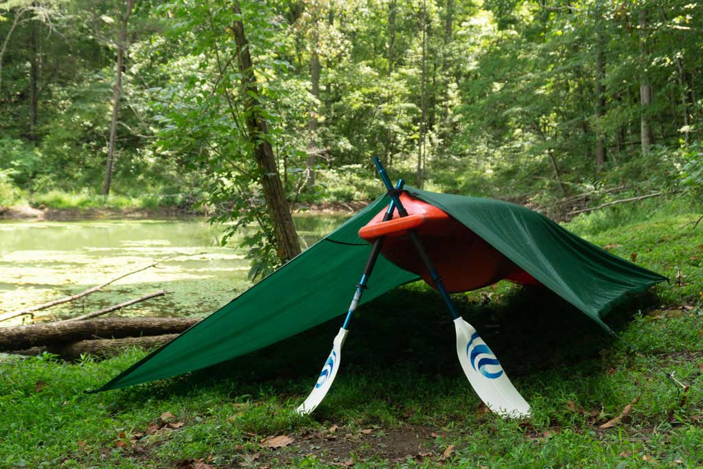 a shelter made from a kayak and paddles