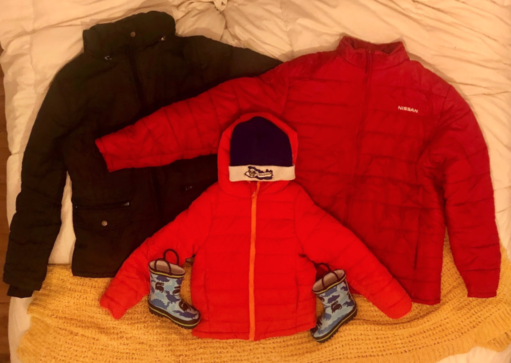 three winter jackets on a bed