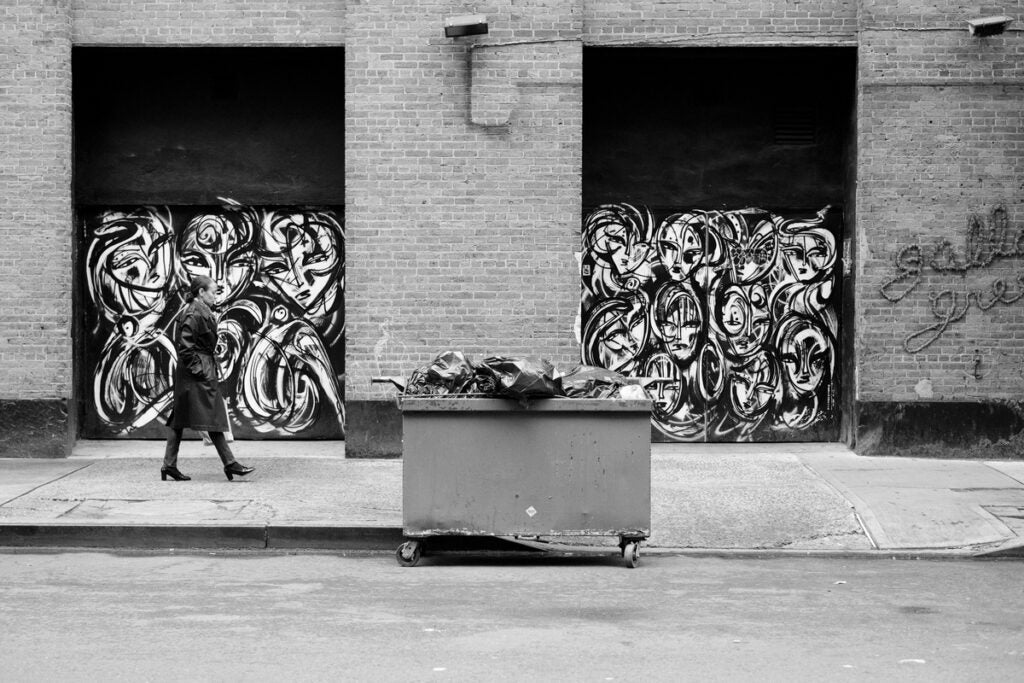pedestrian against black and white mural