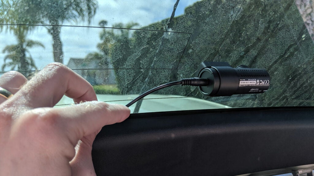 hand-installing a dash camera in a car