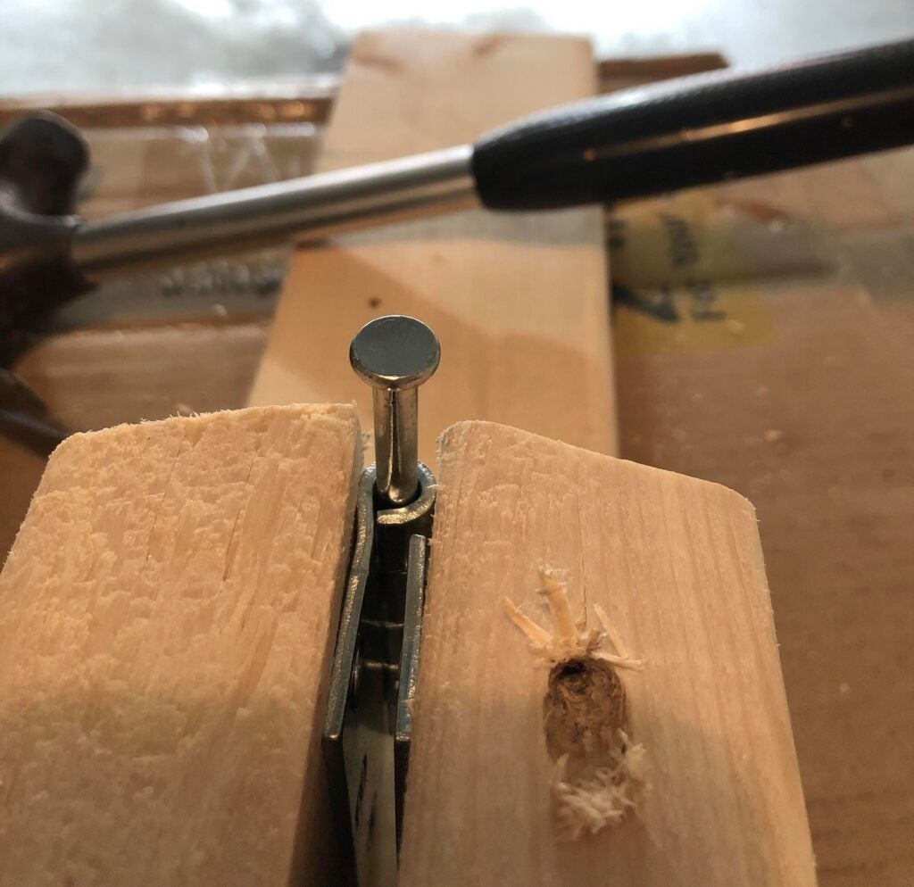 the pin in the hinge of a folding saw horse