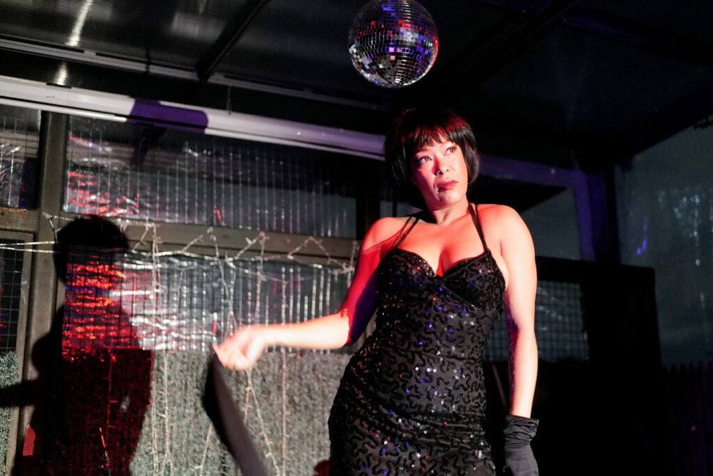performer in black dress under disco ball
