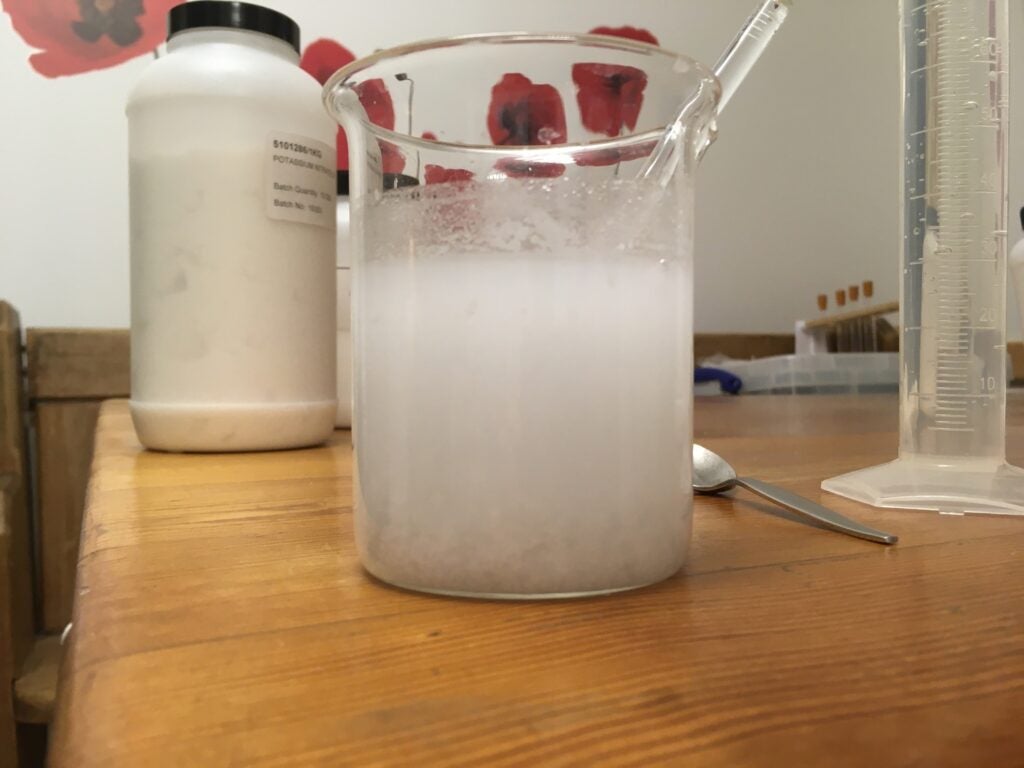 a storm glass mixture in a beaker that's too cloudy and needs more methylated spirits or denatured alcohol