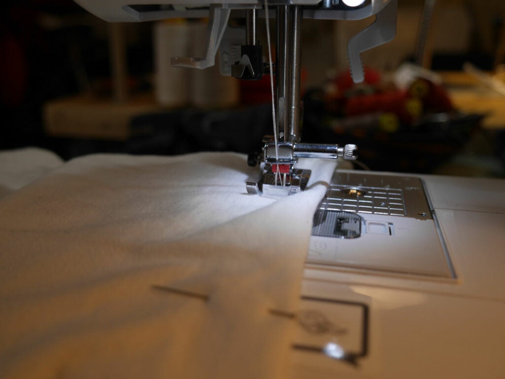 a sewing machine stitching a t-shirt hem with a double needle