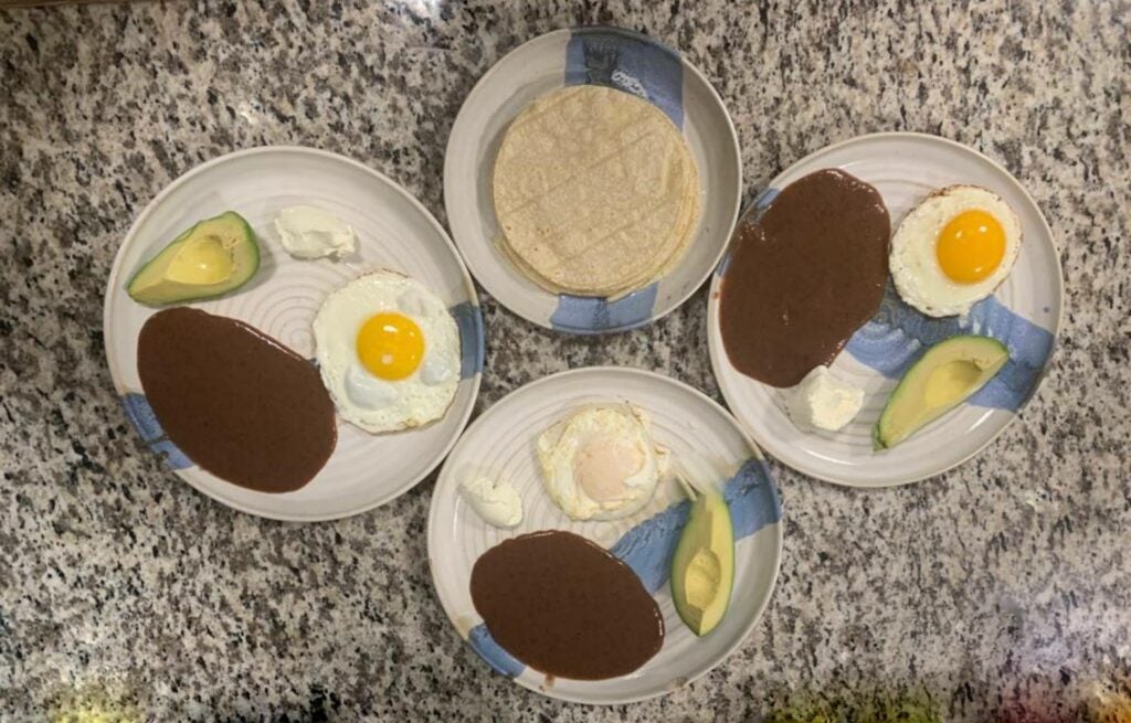 Refried beans served with eggs, cheese and avocado.