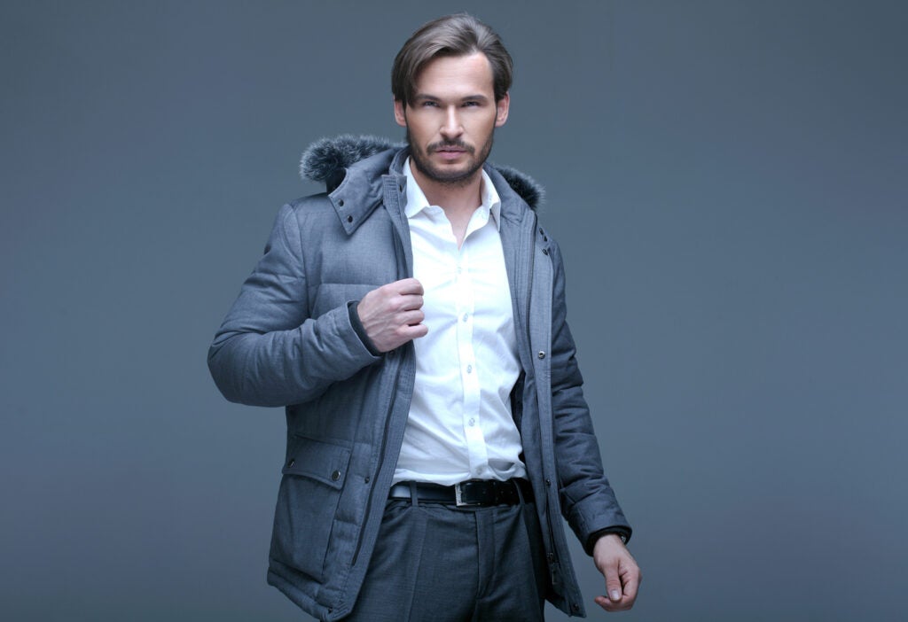 a handsome man in a puffy winter jacket with a patch pocket, dress shirt, and pants