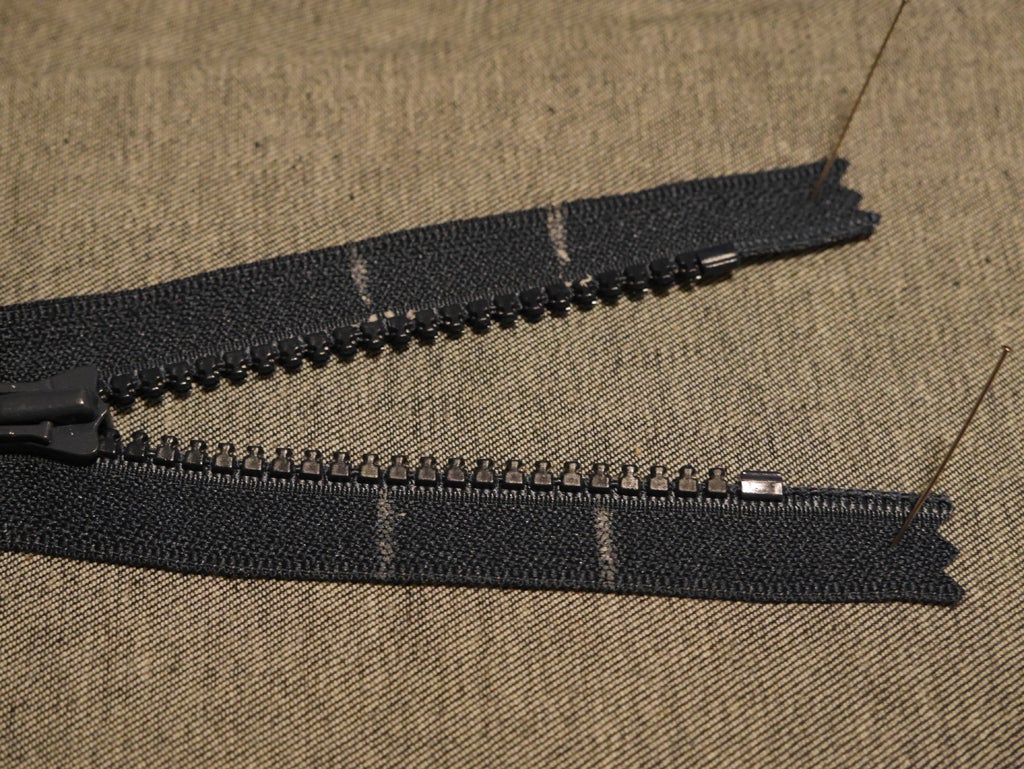 a black zipper with tailor's wax marking inches for shortening