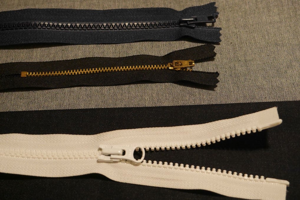 three jacket zippers, some metal, some plastic