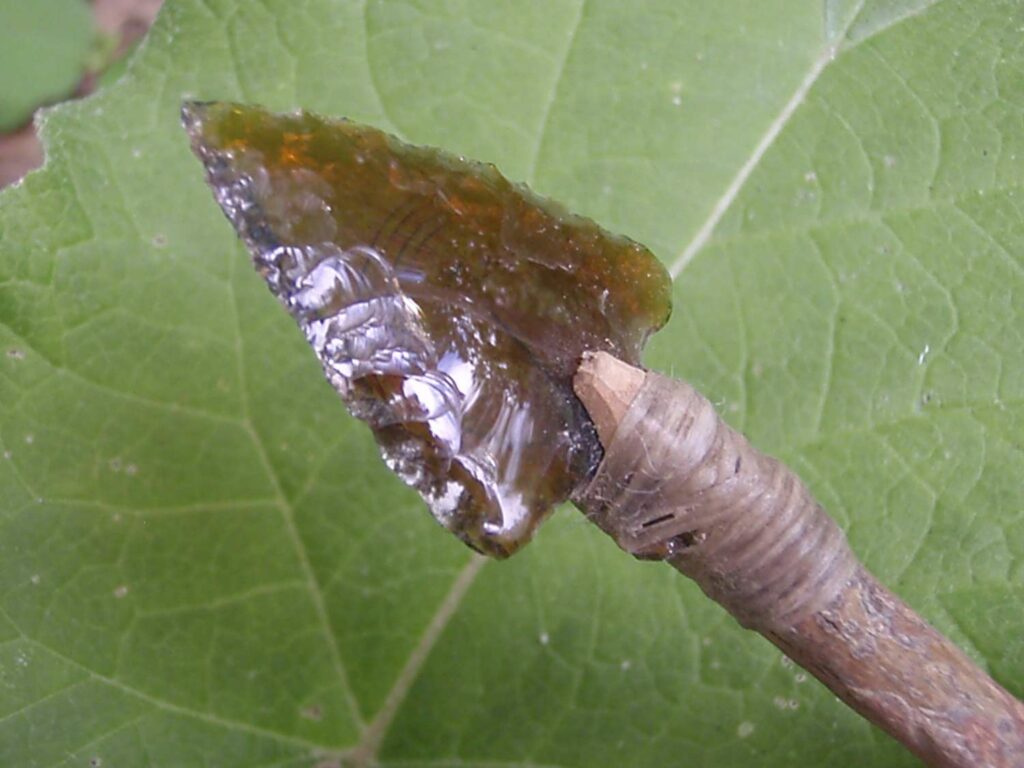 A glass arrowed knipped from the shards of a broken beer bottle.