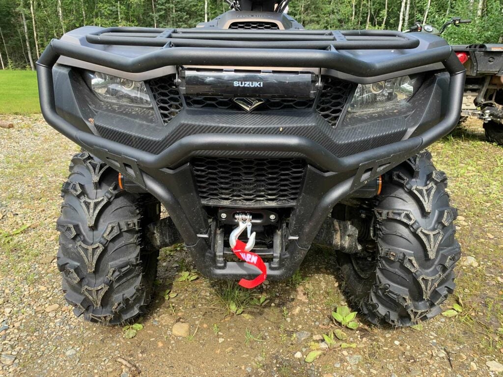 The front of a Suzuki four-wheeler ATV equipped with bumpers and a winch.
