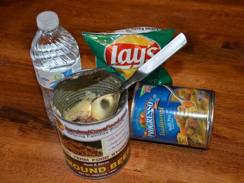 An assortment of canned goods and chips and bottles of water.