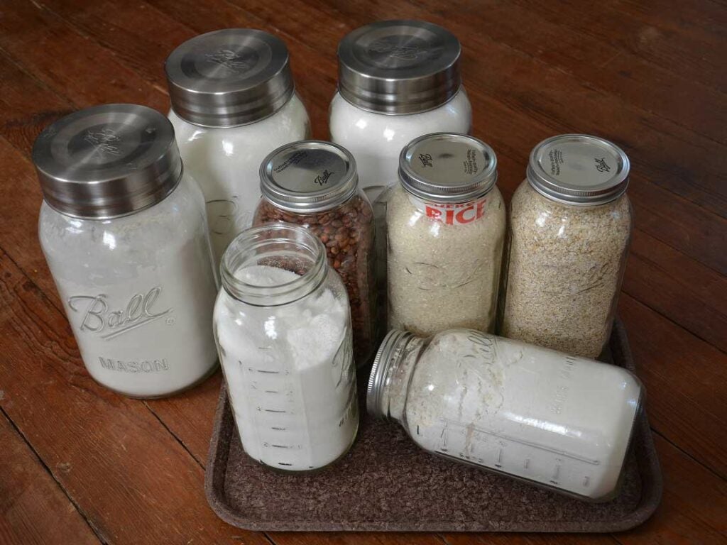 8 glass jars full of dry good supplies.