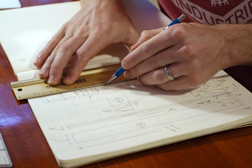 a person drawing plans for an exterior door in a notebook
