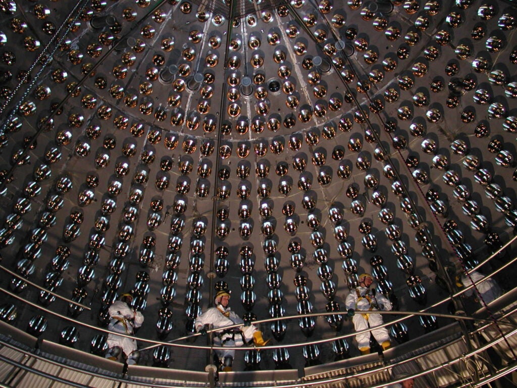 Workers install phototubes in the detector’s core, before it was filled with hundreds of tons of liquid.